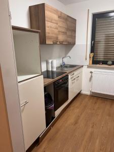 a small kitchen with a sink and a refrigerator at Monteurunterkunft Heger - Beste Verkehrsanbindung in Aalen