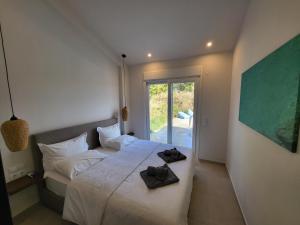 een slaapkamer met een bed met twee handdoeken erop bij Casa O' - Moderne Villa mit großer Terrasse und privatem Swimmingpool in Skala Potamias