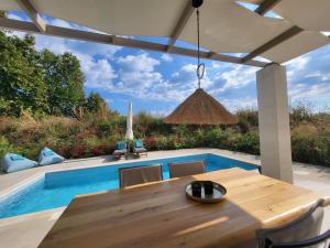 a dining table with chairs next to a swimming pool at Casa O' - Moderne Villa mit großer Terrasse und privatem Swimmingpool in Skala Potamias
