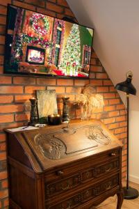 an old wooden chest against a brick wall with a tv at Dluga 66 Attic in Gdańsk