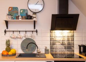 a kitchen with a sink and a clock on the wall at Dluga 66 Attic in Gdańsk