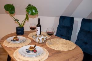 a wooden table with two glasses of wine and food at Dluga 66 Attic in Gdańsk