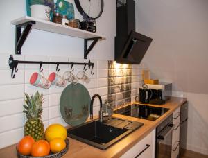a kitchen with a sink and a bowl of fruit at Dluga 66 Attic in Gdańsk