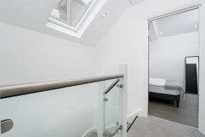 a white staircase in a room with a bedroom at Oxford Street 2 Bedr, 3 Beds, 2,5 Bath, 2 min subway in London