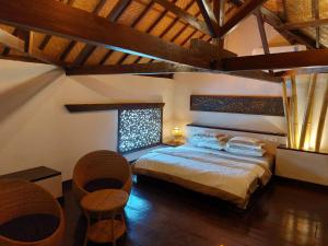 Un dormitorio con una cama y algunas sillas. en Cantika Villa en Gili Trawangan