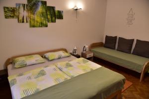 a bedroom with two beds and a couch at Primula Apartment in Blejska Dobrava