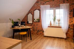 a dining room with a table and a brick wall at Dluga 66 Attic in Gdańsk