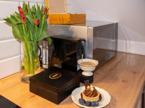 a table with a plate of cake and a microwave at Dluga 66 Attic in Gdańsk