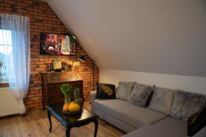 a living room with a couch and a brick wall at Dluga 66 Attic in Gdańsk