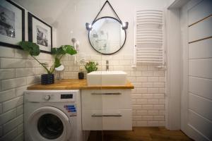 a bathroom with a washing machine and a mirror at Dluga 66 Attic in Gdańsk