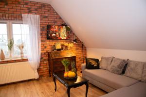a living room with a couch and a brick wall at Dluga 66 Attic in Gdańsk