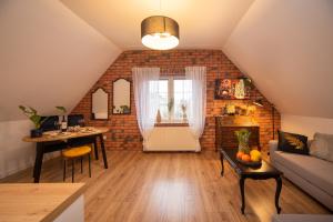 a living room with a couch and a brick wall at Dluga 66 Attic in Gdańsk