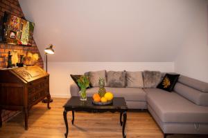 a living room with a couch and a table with fruit on it at Dluga 66 Attic in Gdańsk