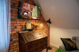 a room with a brick wall with a television on a brick wall at Dluga 66 Attic in Gdańsk