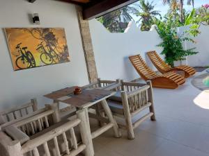 una mesa de madera y sillas en un patio en Cantika Villa en Gili Trawangan