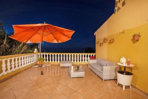 d'une terrasse avec un parasol orange sur le balcon. dans l'établissement Casa La Victoria, à La Victoria de Acentejo