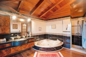 La grande salle de bains est pourvue d'une baignoire et de deux lavabos. dans l'établissement Casa La Victoria, à La Victoria de Acentejo