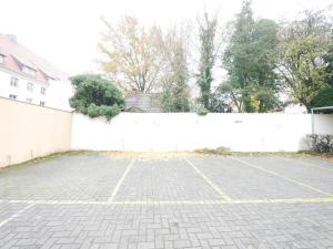 a parking lot in front of a white fence at 75 m2, zentral, gemütlich, eigener Parkplatz in Osnabrück