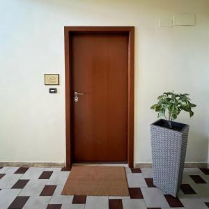 a brown door with a potted plant next to it at Donna Viruzza in Schiavonea