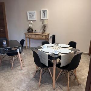 a dining room with a table and black chairs at Donna Viruzza in Schiavonea