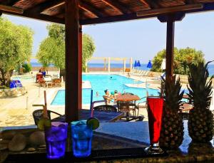 a view of a swimming pool with glasses on a table at Maranton Beach Hotel in Koinyra
