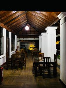 une salle à manger avec des tables et des chaises en bois dans l'établissement Sadamadala Guest House Kandy, à Kandy