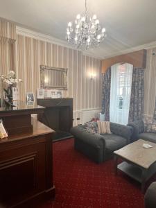 ein Wohnzimmer mit Sofa und Klavier in der Unterkunft Hotel Cavendish in London