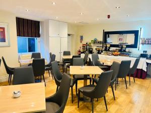 a restaurant with tables and chairs and a kitchen at Hotel Cavendish - Bloomsbury in London +36 photos