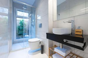 łazienka z umywalką, toaletą i oknem w obiekcie Modita Boutique Apartments w Atenach