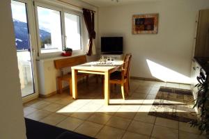 a kitchen with a table and chairs in a room at Apartment Mountain View in Fliess