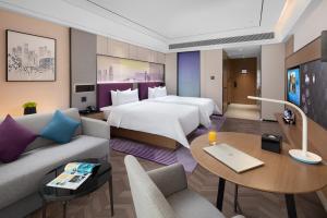 una camera d'albergo con un letto e un soggiorno di Hampton By Hilton Shenzhen Futian Mangrove Park Apartments a Shenzhen