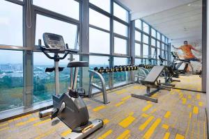 een fitnessruimte met twee loopbanden in een gebouw met ramen bij Hampton By Hilton Shenzhen Futian Mangrove Park Apartments in Shenzhen