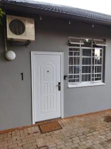 a house with a white door and a window at 21on2nd Avenue in Tzaneen