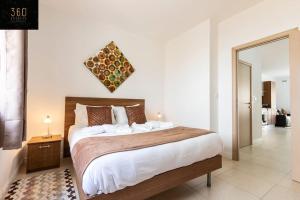 Un dormitorio con una cama grande y un espejo. en Beautiful, TOP NOTCH 1 BR APT just off the coast by 360 Estates, en St Paul's Bay