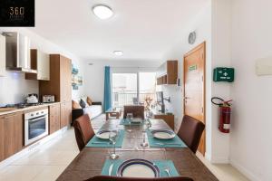 Una cocina y un comedor con mesa y sillas. en Beautiful, TOP NOTCH 1 BR APT just off the coast by 360 Estates, en St Paul's Bay
