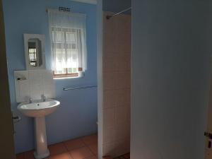 ein Bad mit einem Waschbecken und einem Fenster in der Unterkunft Rainbow Glen Self Catering Chalets in Montagu