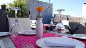 une table avec un tissu de table rose et deux verres à vin dans l'établissement Riad Nafis, à Marrakech