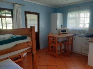 a bedroom with a bunk bed and a kitchen with a desk at Rainbow Glen Self Catering Chalets in Montagu