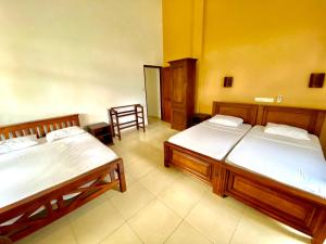 1 dormitorio con 2 camas y 1 silla en Surf Range, en Matara