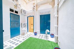 a room with a green carpet and a blue door at DZC- Dazzle Den in Valletta
