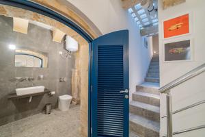 a bathroom with a blue door and a staircase at DZC- Dazzle Den in Valletta