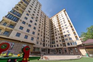 ein großes Apartmenthaus mit einem Pool davor in der Unterkunft Solutel apartments-32 in Bischkek