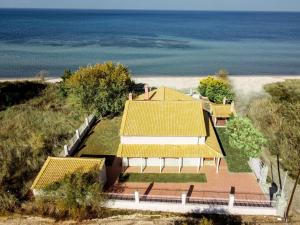 an aerial view of a house with yellow roofs and the ocean at Unique Thasos Beach Villa in Prinos