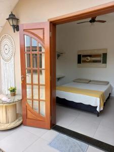 a bedroom with a bed and a open door at Suítes Canola in Ubatuba