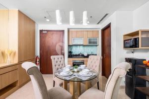 a kitchen and dining room with a table and chairs at MOIRA by Kozystay 2BR Great Location & Bathtub in Jakarta