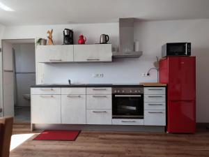 uma cozinha com um frigorífico vermelho e um fogão em Ferienwohnung Trifts | Einzelbetten | Parkplatz em Wangen im Allgäu