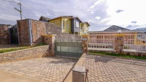 una casa amarilla con una puerta y una valla en Da Vinci House, en Kigali