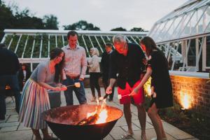 a group of people standing around a fire pit at Hampton Manor in Hampton in Arden