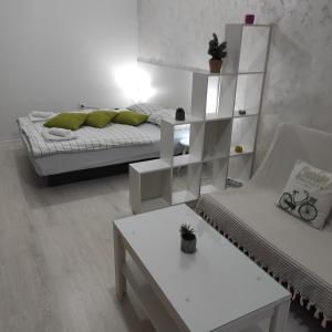 ein weißes Zimmer mit einem Bett und einem Tisch in der Unterkunft Apartman Jevrejska Banja Luka in Banja Luka