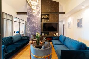 a living room with blue furniture and a blue couch at Warsaw Story - LoftAffair Collection in Warsaw